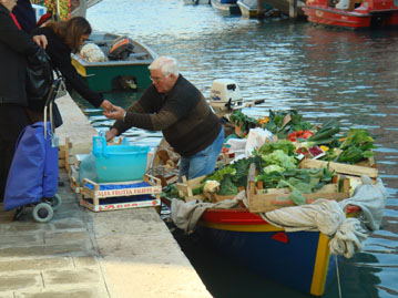 Venice vendor selling vegetables out of his boat